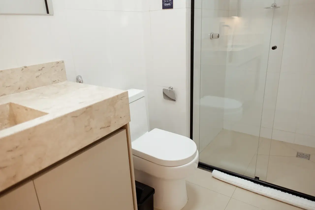 Banheiro com box de vidro e bancada de mármore
