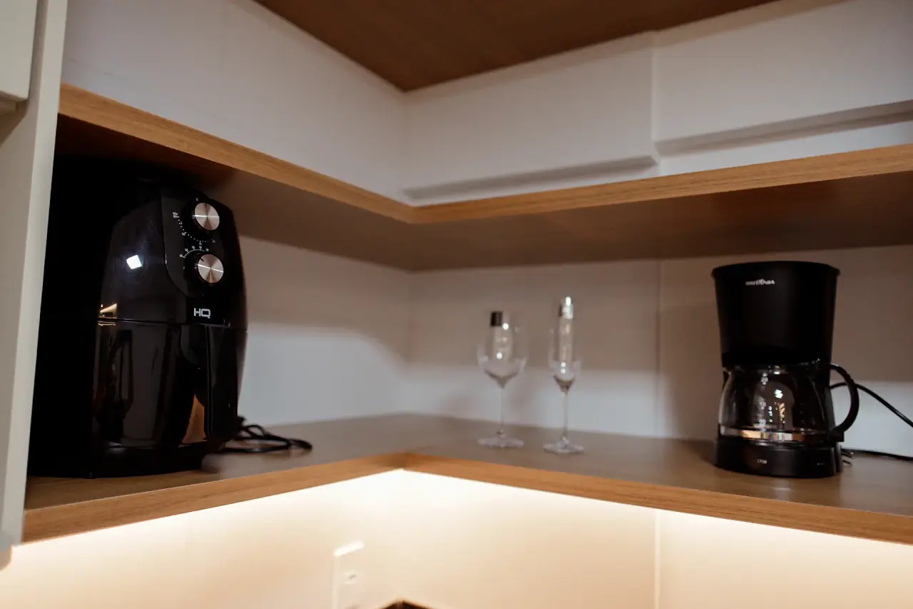 Air fryer, taças e cafeteira na bancada da cozinha