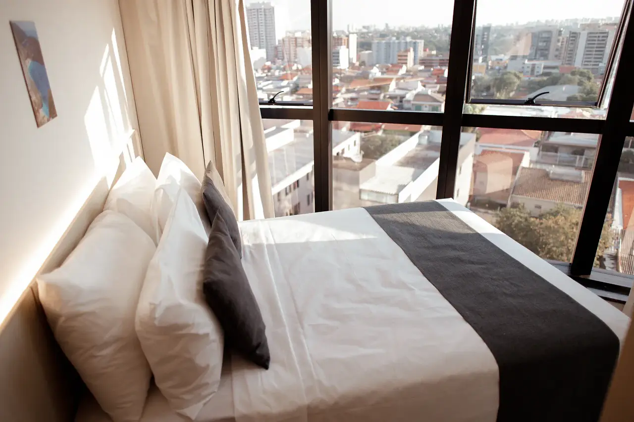 Quarto de casal com janela panorâmica para a cidade